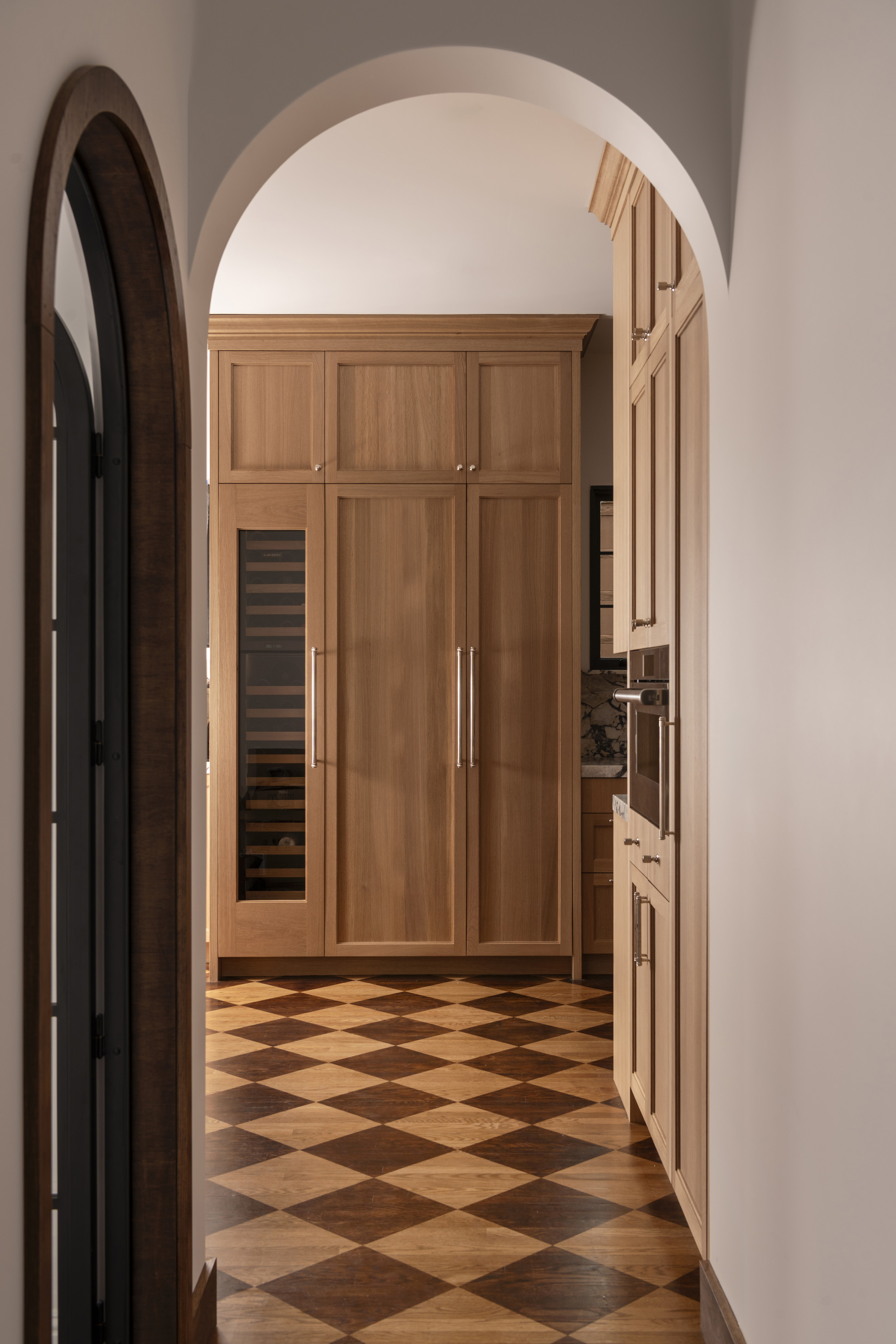 Arched hallway leading to the kitchen entry