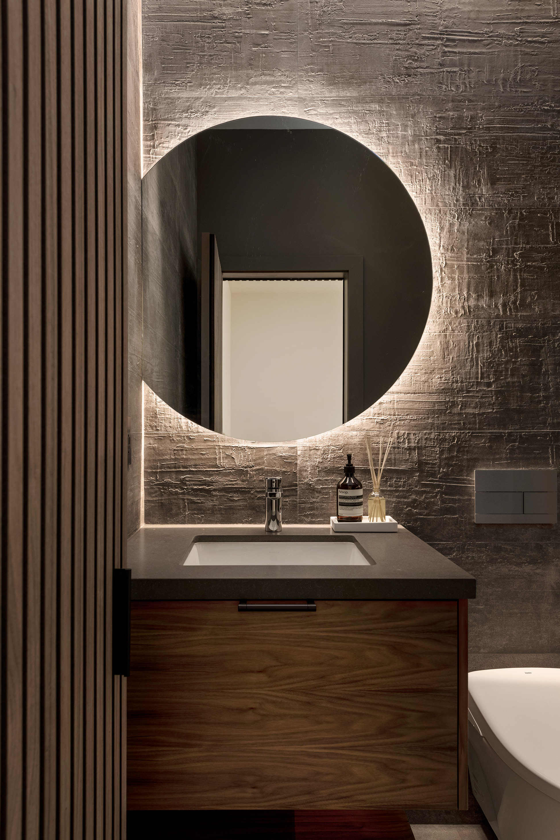 Modern stone wall dark wood bath powder room