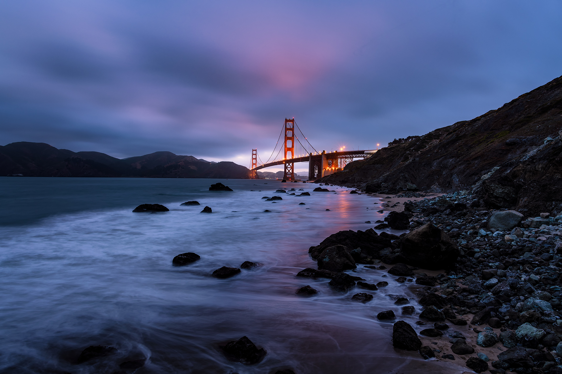 Night photography of the waves drifting in before the Golden Gate Bridge