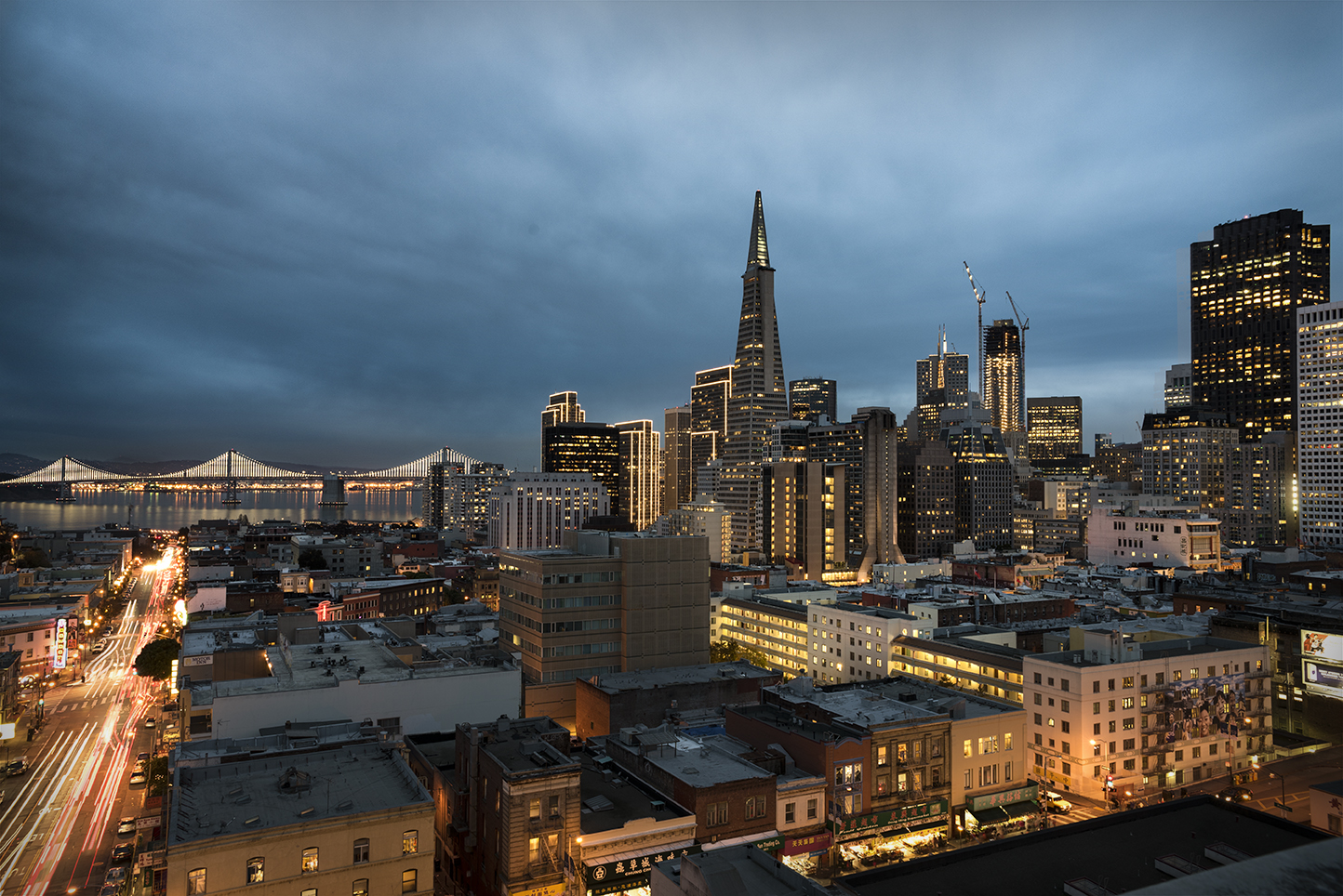 SF city skyline of the Transamerica Pyramid, Bay Bridge and downtown, at evening blue hour
